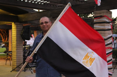 Mohamed Hassani, one of the organizers of Saturday's event in Arcadia Park, proudly holds an Egyptian flag (Photo by Piya Sinha-Roy)
