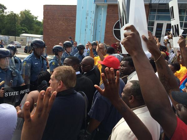 Crowds standing in front of officers chanting, "Don't shoot!" (Twitter/@Mike_Colombo)