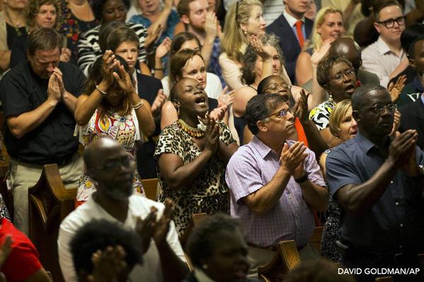 Community members in Charleston, South Carolina come together for a memorial service in response to Wednesday's shooting. ( Photo via David Goldman /Associated Press)