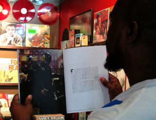 Manager Patrick Washington reads Wax Poetic Magazine. (Celeste Alvarez/Neon Tommy)