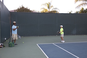 Clarence teaching Asher how to make a better serve (Scarlett Zhiqi Chen/Neon Tommy)