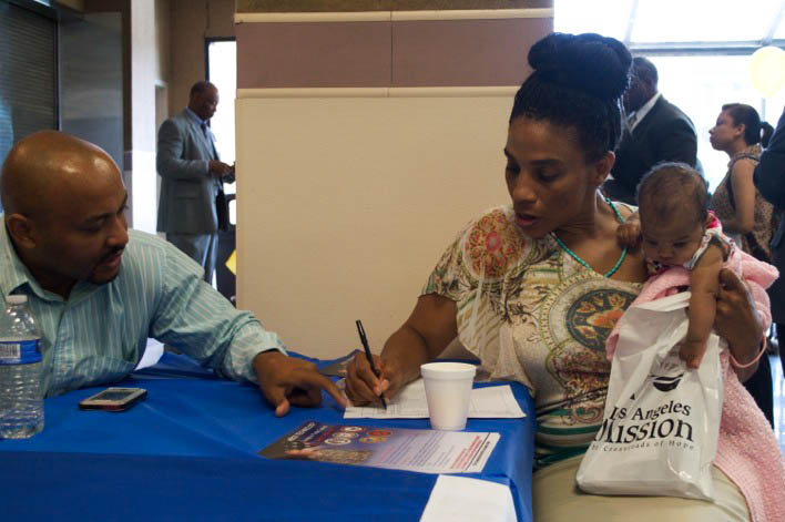 A woman brings her infant daughter along as she fills out applications. (Cassie Paton/Neon Tommy)