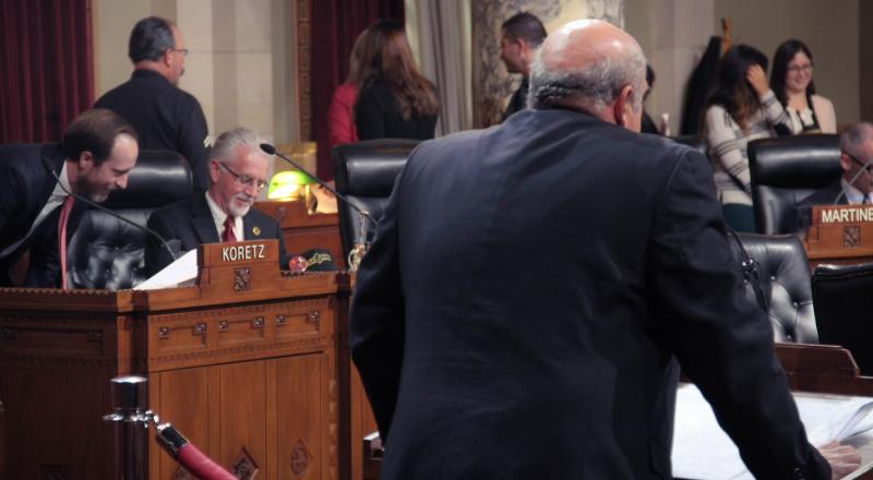 Paul Krekorian (left), the incumbent, speaks with his communications director, Ian Thompson (far left). Krekorian’s opponent, Eric Preven (right), makes a 60-second statement about planning and land use management during a city council public hearing. 