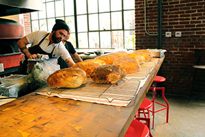 Freshly baked bread lined up in front of Bestia's open kitchen (Kaitlyn Mullin/Neon Tommy)