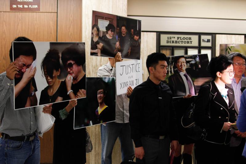 Supporters of slain USC student hold up signs demanding "Justice for Xinran Ji" next to images of Ji and his grieving parents. (Sophia Li / Neon Tommy)