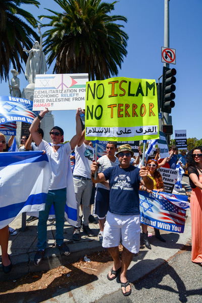 A man stands proudly with his sign decrying Islam. (Matthew Tinoco/Neon Tommy)