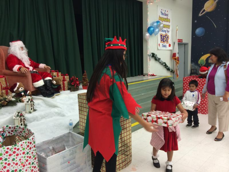 Kids receive toys donated by USC student groups and other sponsors from a KYCC elf(Michelle Tak/Neon Tommy)