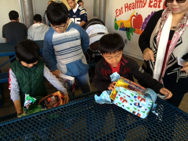 Kids unwrap their gifts from the toy drive. (Michelle Tak/Neon Tommy)