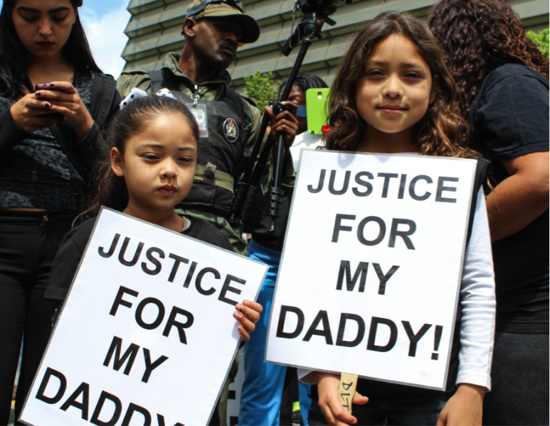 Jose de la Trinidad’s youngest daughter holds a sign that reads ‘Justice for my daddy,’ during an organized march against police brutality on April 6, 2015. (Ashley Velez/Neon Tommy)