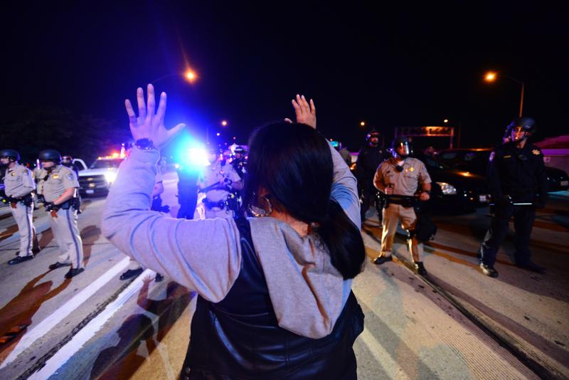 A protestor does the "Hands Up, Don't Shoot" sign at a protest in Los Angeles following the decision not to indict the officer who shot Mike Brown. (Charlie Magovern/Neon Tommy)