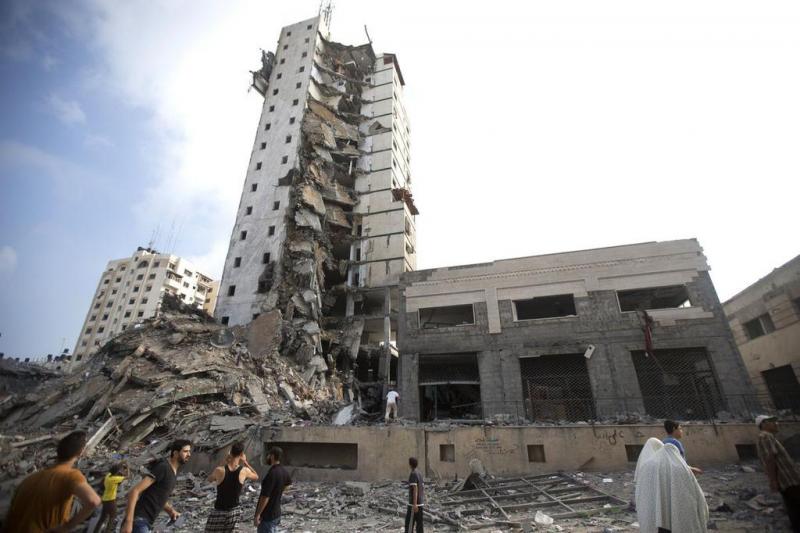 Israeli air strikes topple two high-rise buildings in the Gaza Strip. (Mahmud Hams/Bloomberg News via Twitter)