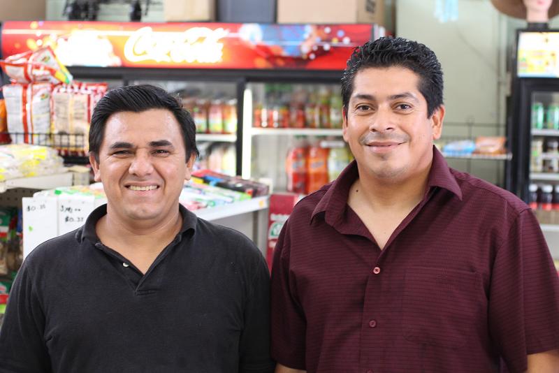 Carlos Fernandez, right, owns Eben-Ezer Dollar Plus with his brother-in-law Leonel Mancia, left, and sister, not pictured. (Taylor Haney/Neon Tommy)