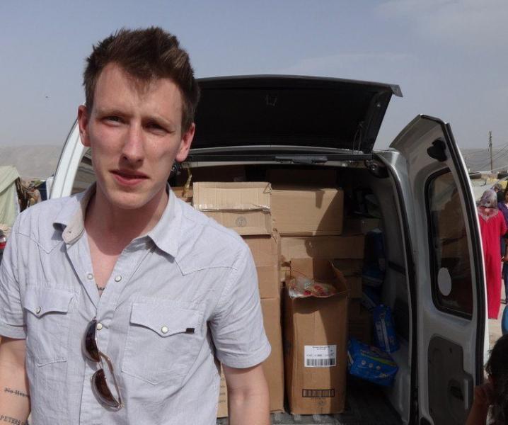Peter Kassig standing in front of a truch near the Syrian border delivering supplies to refugees before being held captive by ISIL. (AFP/Getty Images)