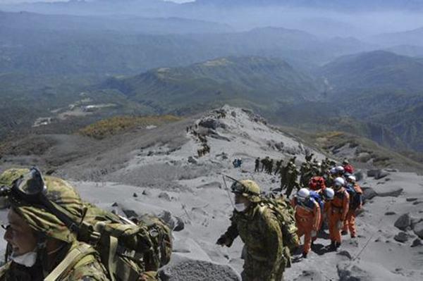 Rescue workers climb Mt. Ontake searching for the missing after Saturday's eruption. (SFGate/Twitter)