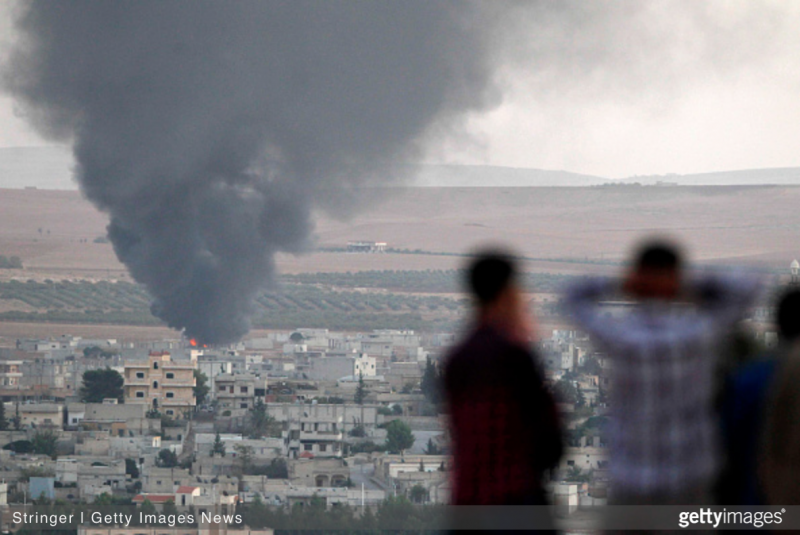 Turkish Kurds watch the town of Kobani after bomb strikes. (Striker/Getty Images)
