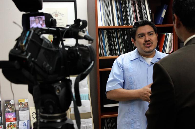 CHIRLA Communications Director Jose-Mario Cabrera gives multiple media interviews in a chaotic morning at the office after President Obama's speech. (Rachel Cohrs/Neon Tommy)