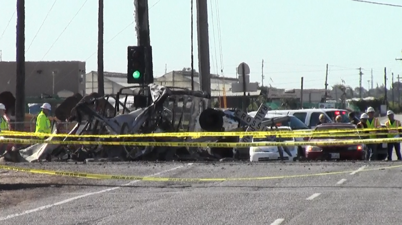 Fire scorched the car and the train's impact split the car in two Fire scorched the car and the train's impact split the car in two