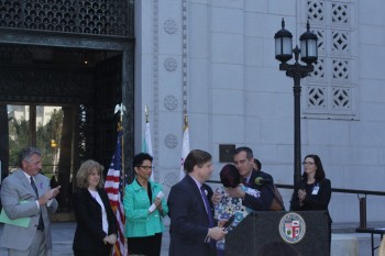 Los Angeles Mayor Eric Garcetti hugs a domestic violence survivor identified as Destiny at a news conference outside of City Hall on Thursday, Oct. 1. (Whitney Ashton/Annenberg Media)