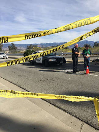 Law enforcement officials stand behind a police line near the site of the San Bernardino mass shooting. (Whitney Ashton/Annenberg Media)