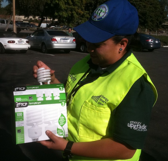 Corpsmember Yvette Becerra holds a 27 watt Compact=