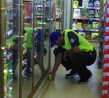 Corpsmember Rashad Acklin makes measurements for an LED lighting upgrade. 