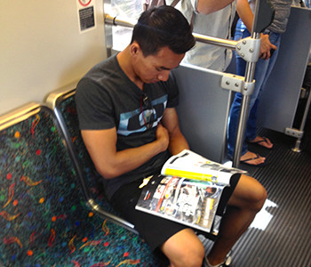 Kadek Rabindra reads magazine on Metro Gold Line. (Michael Radcliffe / Annenberg Media)