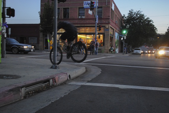 Hopping a curb on York Boulevard, Bob rides back to close up his shop. (Taken by Nathan Carzon) Hopping a curb on York Boulevard, Bob rides back to close up his shop. (Taken by Nathan Carzon)