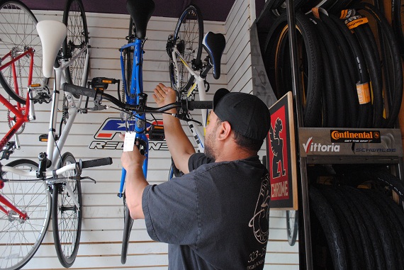 Bob, the Bicycle Doctor, hangs up a bike after a child and his father came in asking for a fixie-type bike. Bob is always eager to help out customers, especially children. (Taken by Nathan Carzon)