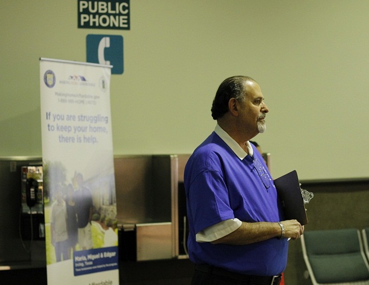 Mark Foster, a volunteer at the event, is also a realtor who negotiates loan modifications with struggling clients. He himself is also facing foreclosure on rental properties. For him, the process has taken a turn for the absurd. (Photo by Aaron Liu)