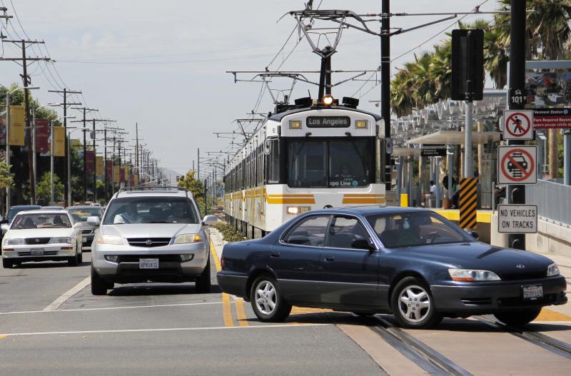 An Expo light-rail train stops and waits as cars turn left. (Rosa Trieu)