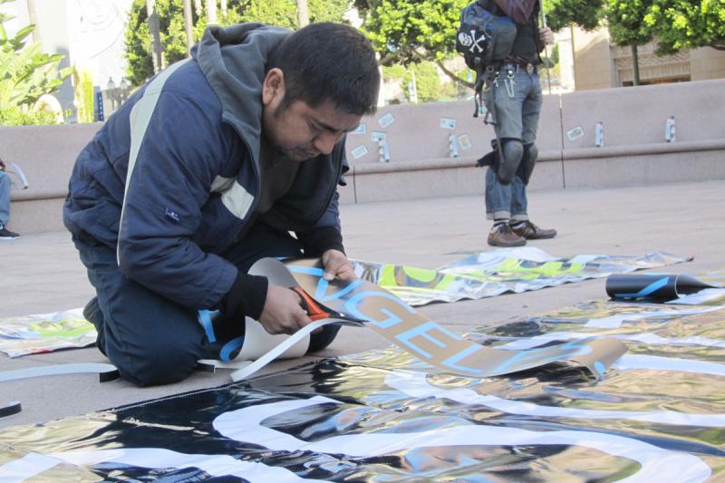 Protester Arturo Blas prepares a banner in Pershing Square for an Occupy Los Angeles anti-foreclosure march on Friday, Jan. 13.