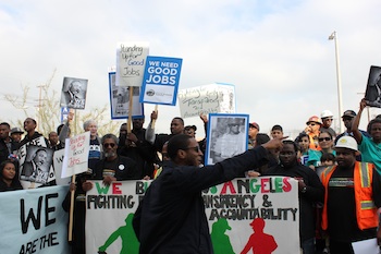 An organizer rallied demonstrators before heading down Western Avenue to join the parade. (Catherine Green)