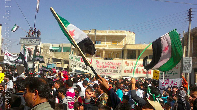 Syrian flags flying over a protest (Courtesy of Creative Commons, FreedomHouse)