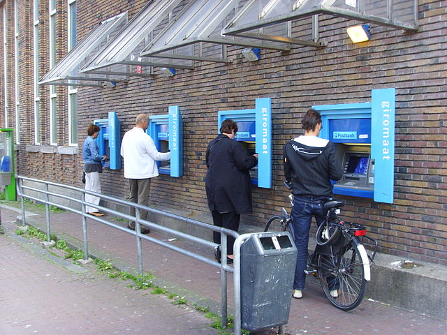 Like-minded consumers forgoing the bankteller experience in favor of ATM efficiency. (Victor van Werkhooven/Wikimedia Commons) Like-minded consumers forgoing the bankteller experience in favor of ATM efficiency. (Victor van Werkhooven/Wikimedia Commons)