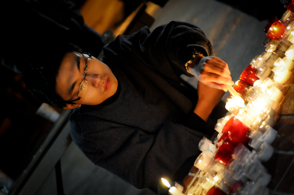 A USC student lights a candle in memory of two graduate students who were killed while sitting in their cars near campus. (Jerry Ting/Neon Tommy)