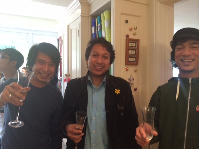 Adam Adli, left, raising his glass at a gathering of Malaysians in London. (Michelle Toh/Neon Tommy)