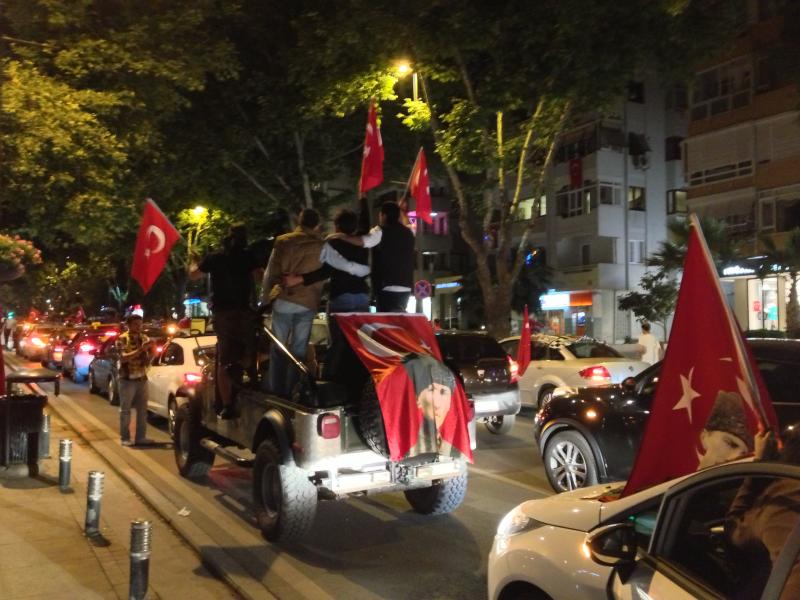 (Four men pose for a picture in stopped traffic. The flag they have draped over their car features Mustafa Kemal Ataturk, the father of the Turkish secular state./ Tahsin Hyder, Neon Tommy)