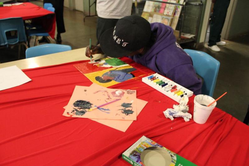 A participant in the 'Art with a Mission' event on Skid Row paints (Benjamin Li/Neon Tommy) 