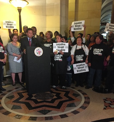 Los Angeles Street Vendors Campaign members chant "Si se puede!" ("Yes we can!") behind Councilman Huizar at the rally before the Economic Development Committee meeting Tuesday. (Emily Goldberg/Neon Tommy)