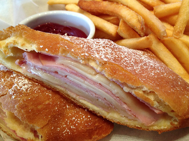 The “Monte Cristo” sandwich features a classic yeast donut roll filled with Black Forest ham and gruyere cheese and is topped with powdered sugar and served with a side of strawberry jam (Kelli Shiroma / Neon Tommy).