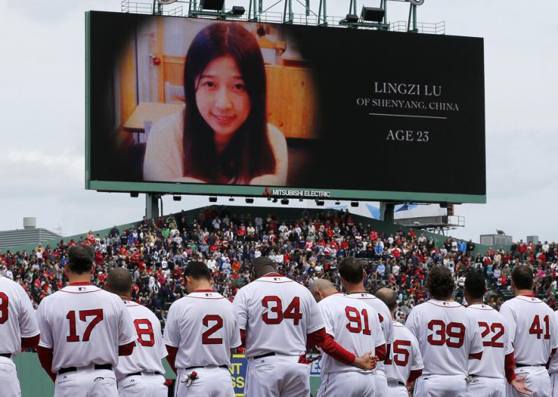 The Boston Red Sox stand during tribute to Boston Marathon bombing victims, including Chinese student Lingzi Lu, before a baseball game against the Kansas City Royals in Boston, Saturday, April 20, 2013. Michael Dwyer/AP