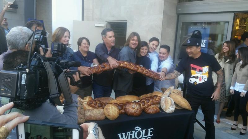 Whole Foods executives break bread in order of the grand opening. (Lamarco McClendon/Neon Tommy)