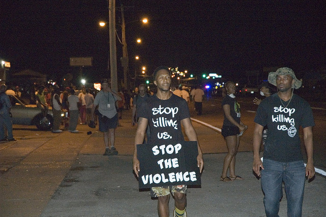 Ten days after the shooting of Michael Brown on Aug. 9, protesters in Ferguson, Missouri rallied on the streets wearing shirts that state, "Stop killing us." (peoplesworld/Creative Commons) Ten days after the shooting of Michael Brown on Aug. 9, protesters in Ferguson, Missouri rallied on the streets wearing shirts that state, "Stop killing us." (peoplesworld/Creative Commons)
